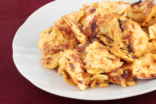 Vegan matzah brei on white plate on maroon tablecloth
